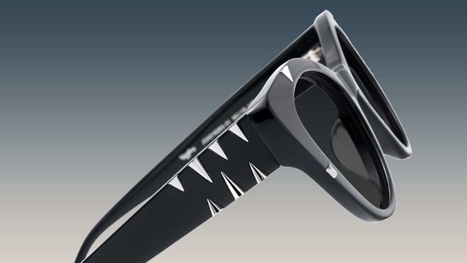A close-up of avant-garde black sunglasses featuring sharp, silver metallic spikes on the arm, showing a bold 2026 style.