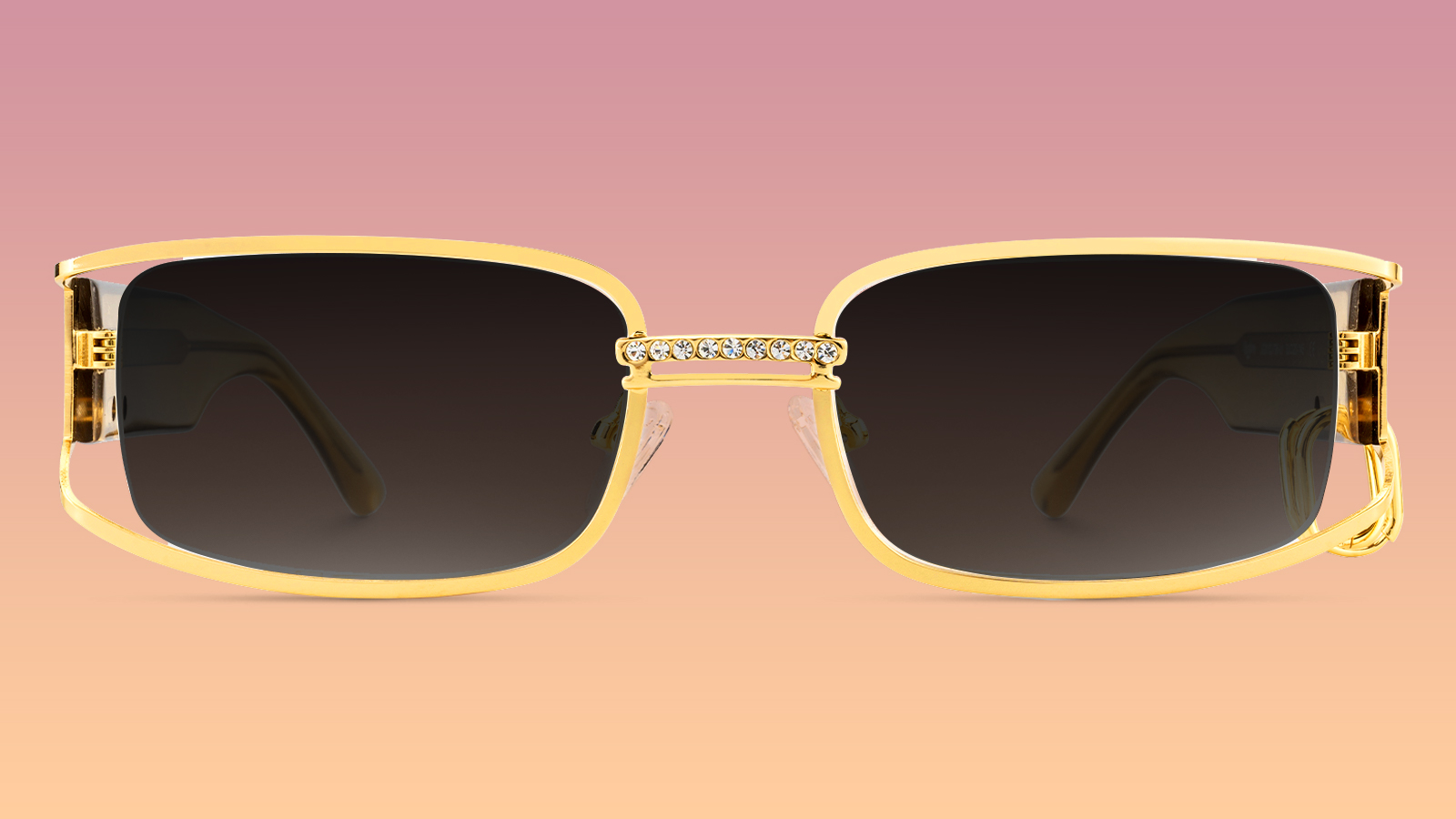 A pair of oversized, gold-framed rectangular sunglasses with a crystal-accented bridge, representing the 2026 maximalist trend.