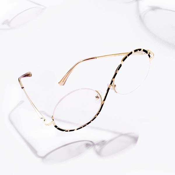 A pair of gold wire-framed glasses with a black and white patterned