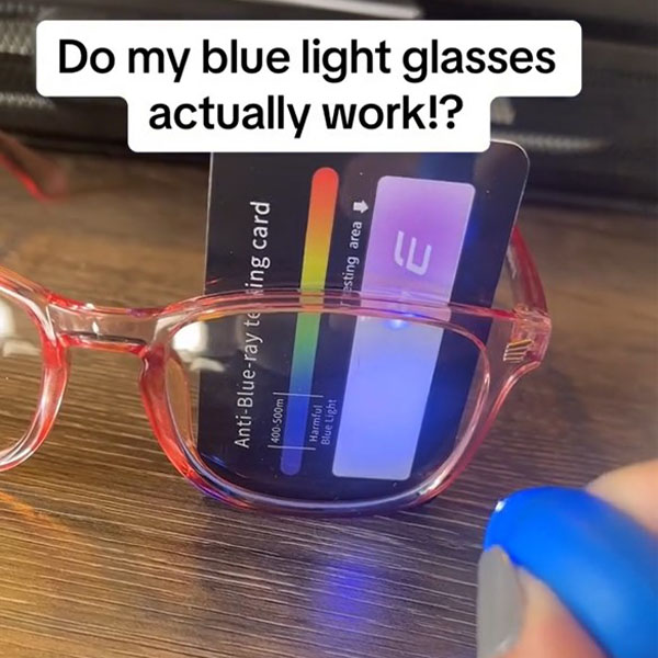 Anti-blue-rays testing card on working a pair red translucent frame glasses